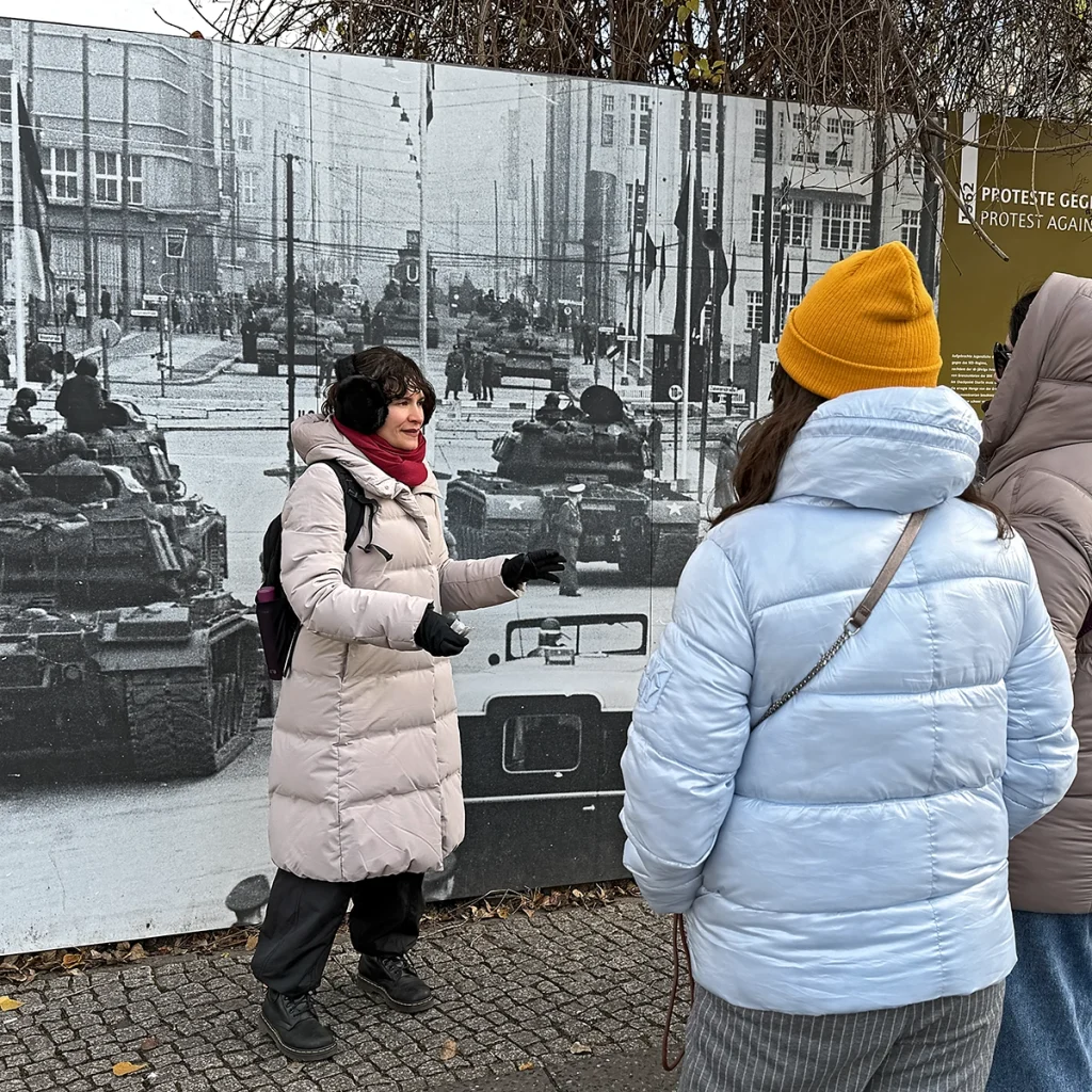 Carmen Guerreiro explica a história da Guerra Fria durante um tour em Berlim no Checkpoint Charlie